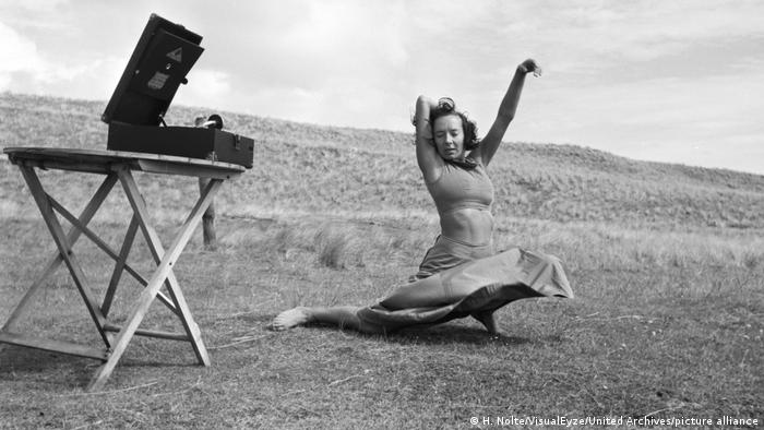Dancer Gret Palucca dances in a field in the 1930s, next to her is a gramophone on a small table
