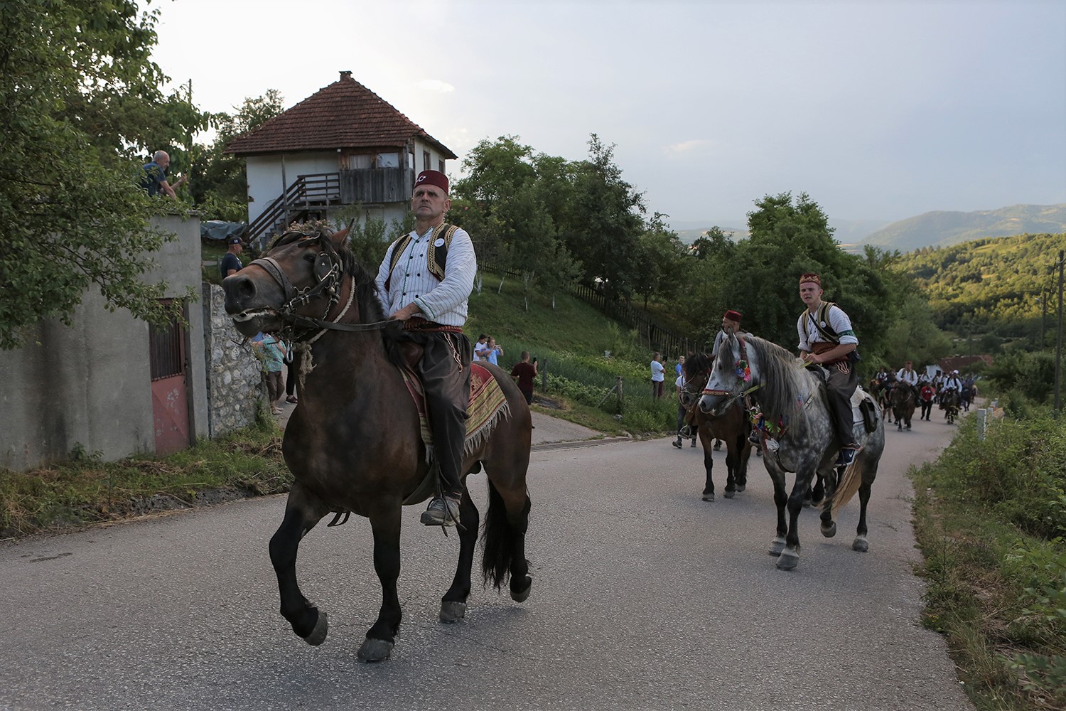 Men on horseback ride up a country road near Prusac, Bosnia and Herzegovina (photo: Konstantin Novakovic)