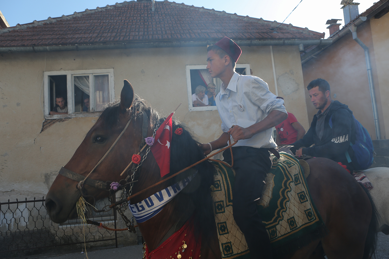 A man on horseback passes a house in Prusac (photo: Konstantin Novakovic)