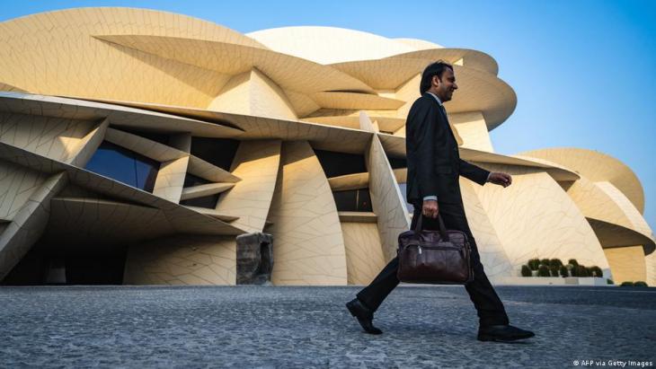 A man walks past the National Museum of Qatar, 13 November 2022 (photo: AFP via Getty Images)