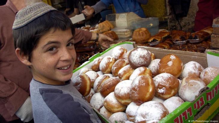 A boy smiles while carrying a cardboard box full of sufganiyot (photo: UPI Photo/Image images)