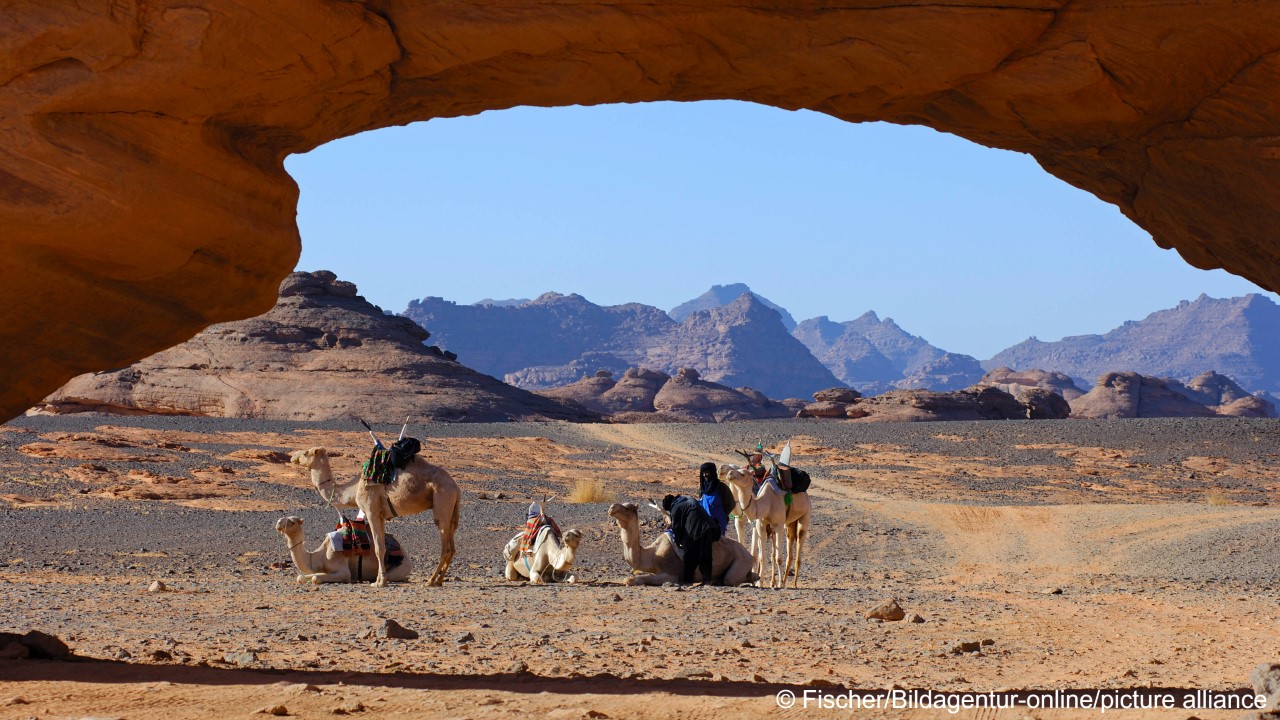 Camel caravan of the Tuareg nomads camp at a rock arch shaped by wind erosion, Acacus Mountains, Libya (photo: Fischer/Bildagentur-online/picture-alliance)