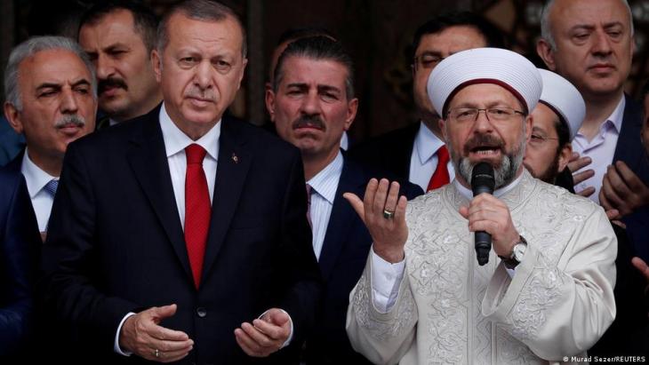 Turkish President Recep Tayyip Erdoğan (left) and head of Turkey's Religious Affairs Directorate Ali Erbas (right) pray during the opening ceremony of a mosque in Istanbul, Turkey, 24 May 2019 (photo: Murad Sezer/Reuters)