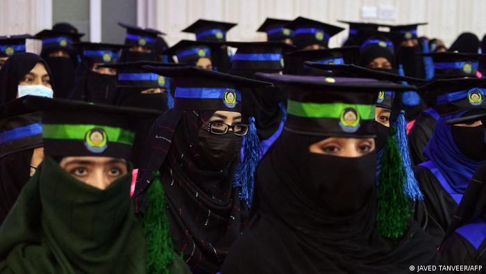Close-up of a group of female graduates. All are wearing a face veil that leaves only the eyes free, and classic graduation hats over the hijab.