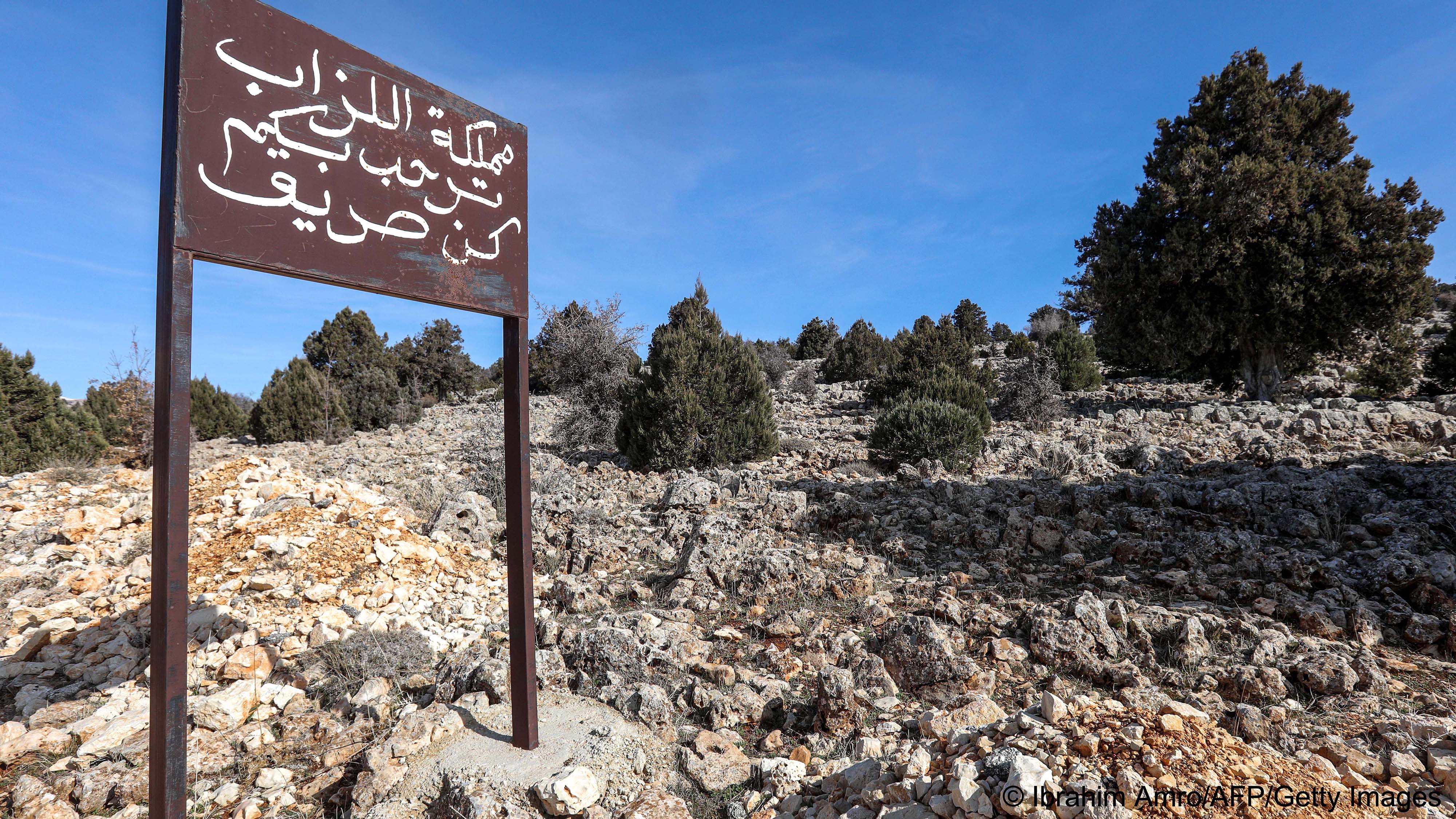Sign in Arabic in front of a hillside planted with trees (image: Ibrahim AMRO/AFP)