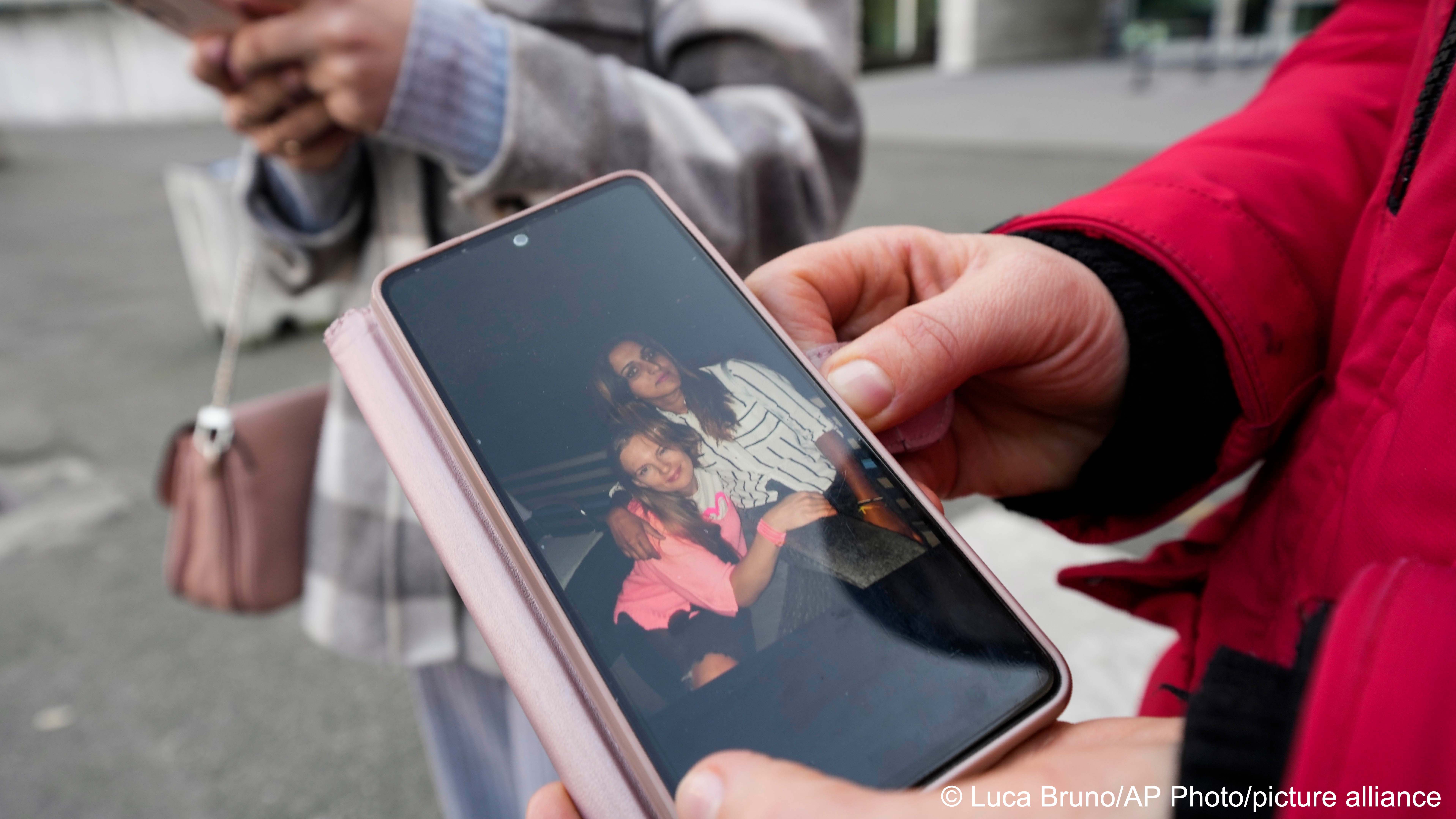Verkalets Olha from Ukraine, shows her smartphone with pictures of her Pakistani-born friend Sana Cheema outside the law court in Brescia, northern Italy, 9 February 2023, after testifying in a hearing of the trial for her murder (image: Luca Bruno/AP Photo/picture alliance)