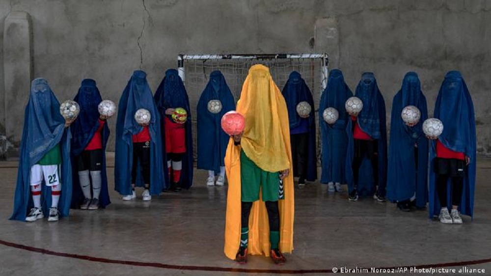 Eine ehemalige Frauen-Fußballmannschaft in Kabul, Afghanistan. Alle tragen Burkas und alle halten einen Ball in der Hand.