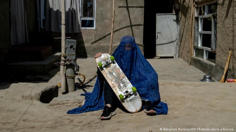 Eine junge Frau mit Skateboard und Burka in Kabul, Afghanistan.