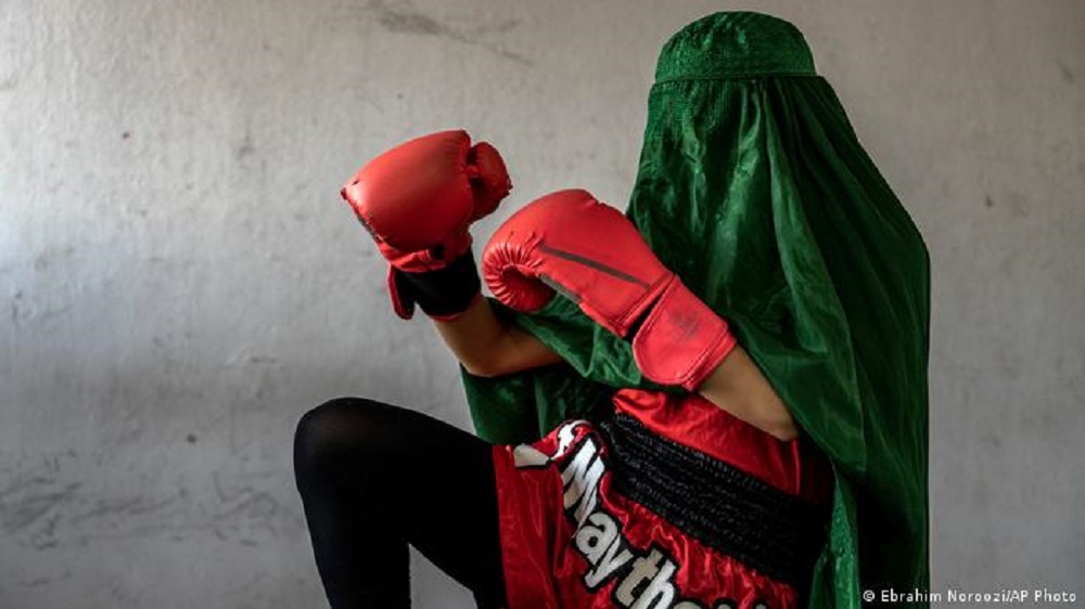 Eine junge Thai-Boxerin in Kabul mit Burka und Boxhandschuhen.