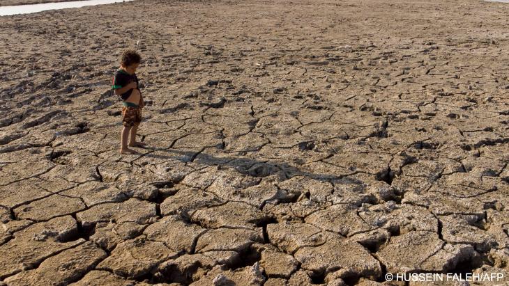 Ein Kind in einer von Dürre betroffenen Ebene im Südirak, Sommer 2022 (Foto: Hussein Faleh/AFP)