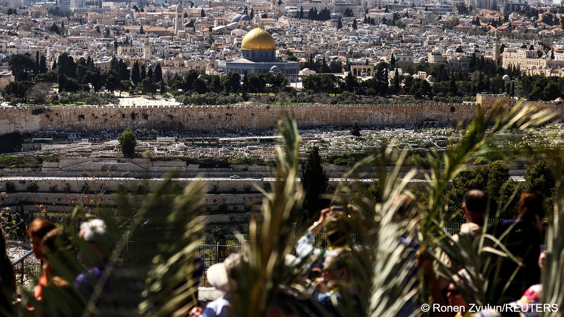 The Dome of the Rock is seen in the background as Christian worshippers attend a Palm Sunday procession on the Mount of Olives in Jerusalem, 2 April 2023 (image: REUTERS/Ronen Zvulun) 