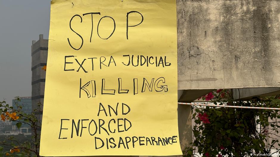 A yellow poster with black writing in capital letters says: 'Stop extrajudicial killings and enforced disappearances' (image: Arafatul Islam/DW)