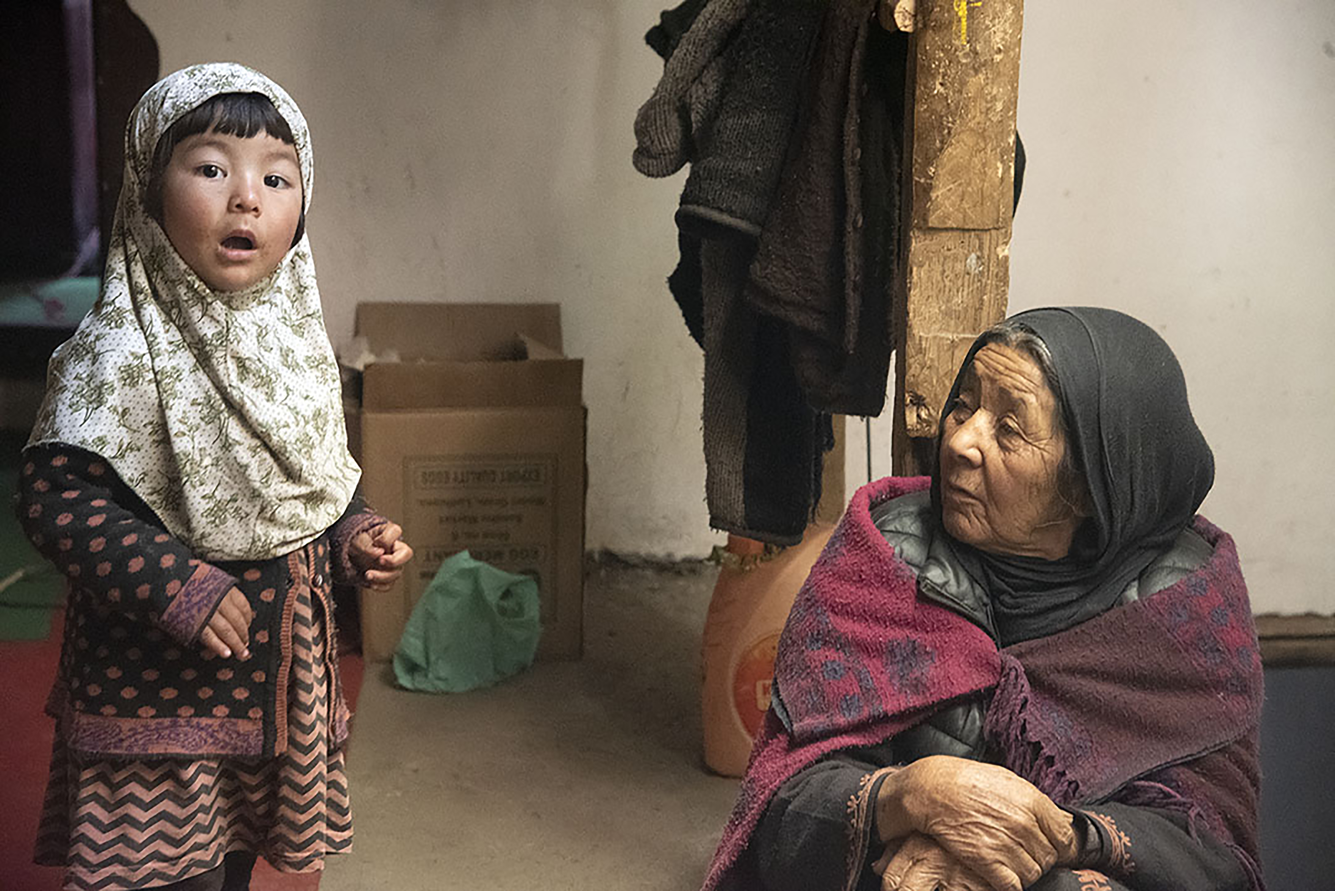 A little girl looks at the camera, while an old woman looks to her; both are wearing headscarves (image: Sugato Mukherjee)