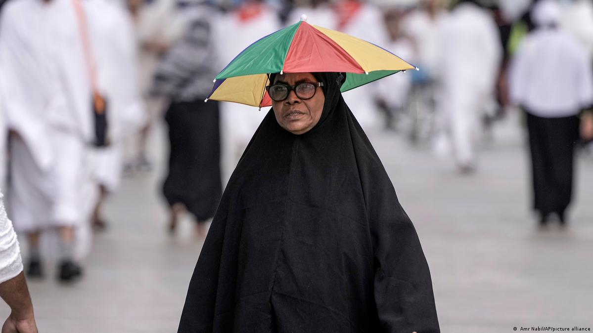 Eine Pilgerin in Mekka schützt sich vor der Sonne mit einem Schirm. (Foto: Amr Nabil/AP/picture alliance) 
