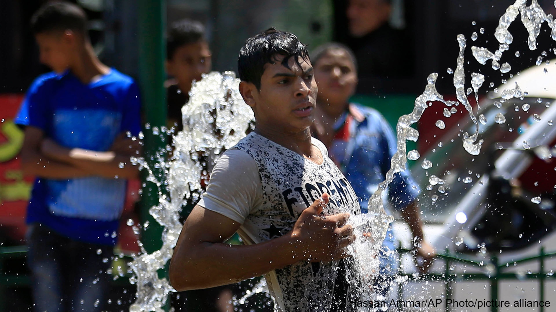 An Egyptian cools off in a public fountain in Giza, Egypt (photo: Hassan Ammar/AP Photo/picture alliance)