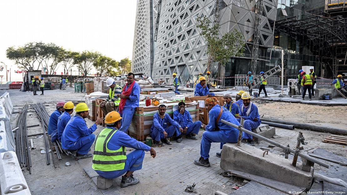 قالت منظمة هيومن رايتس ووتش إن العمالة الوافدة في الخليج معرضون بشكل خاص لخطر الطقس الشديد الحرارة.  Migrant builders take a break while working at a construction site by the Corniche, Doha, 24 November 2022 (photo: Chandan Khanna/AFP/Getty Images)