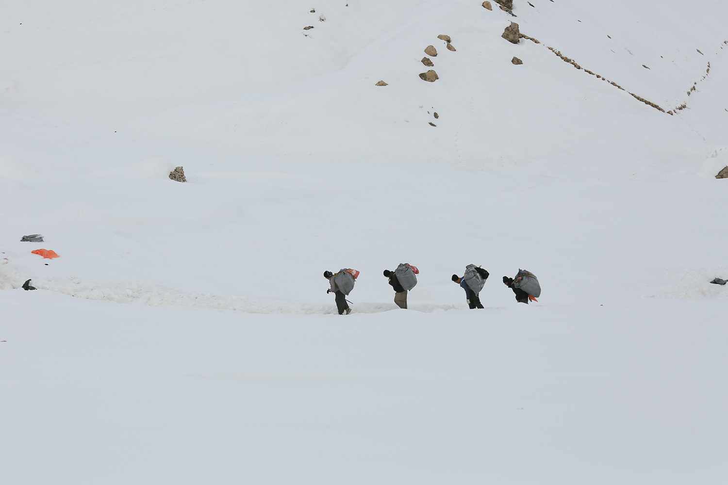 Vier Männer stapfen durch den Schnee in der mittleren Entfernung; Foto: Konstantin Novakovic