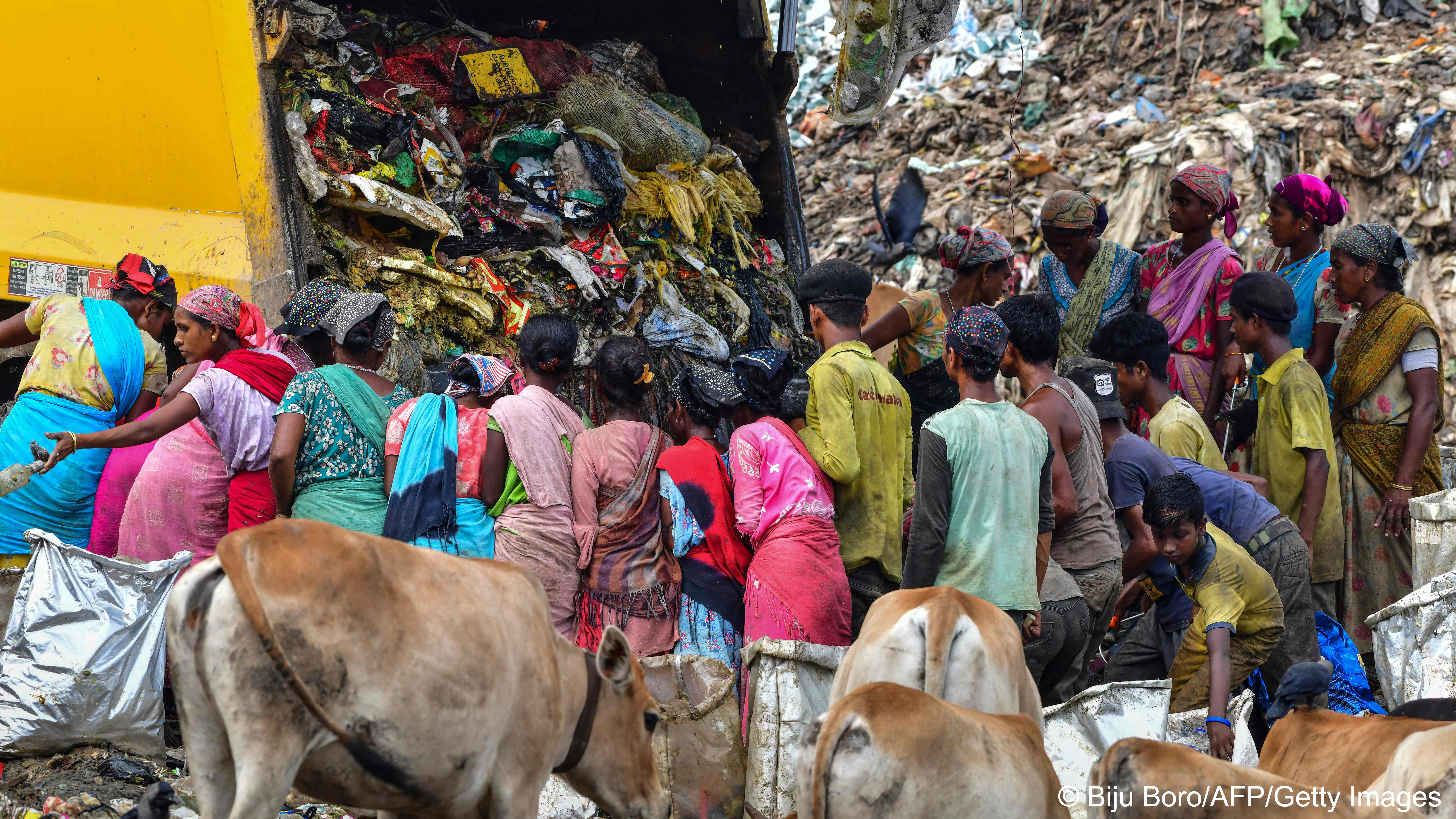 Ragpickers search for recyclable materials as a truck unloads garbage at a dumpsite in Guwahati on 2022 (image: Biju BORO/AFP)