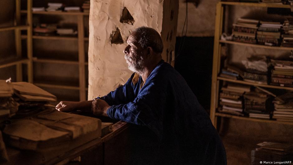 Ahmed Mahmoud sits at a table in his family's library in Chinguetti