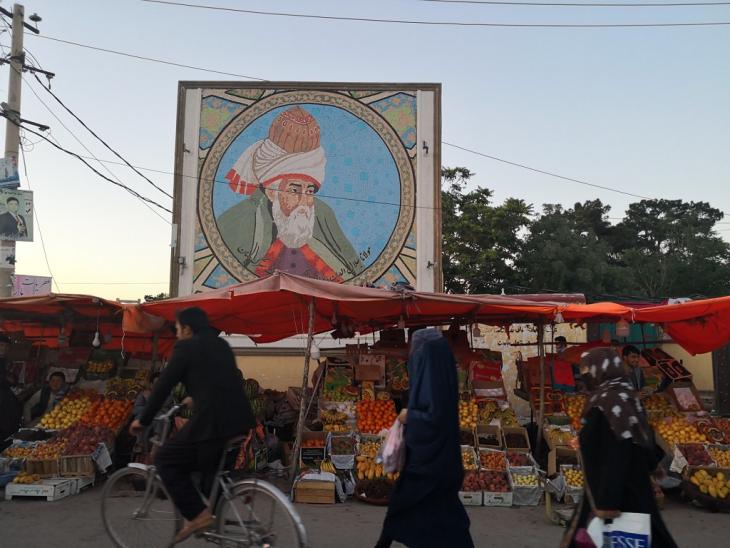 A mosaic of Rumi towers over the bazaar in Mazar-e Sharif (image: Marian Brehmer)