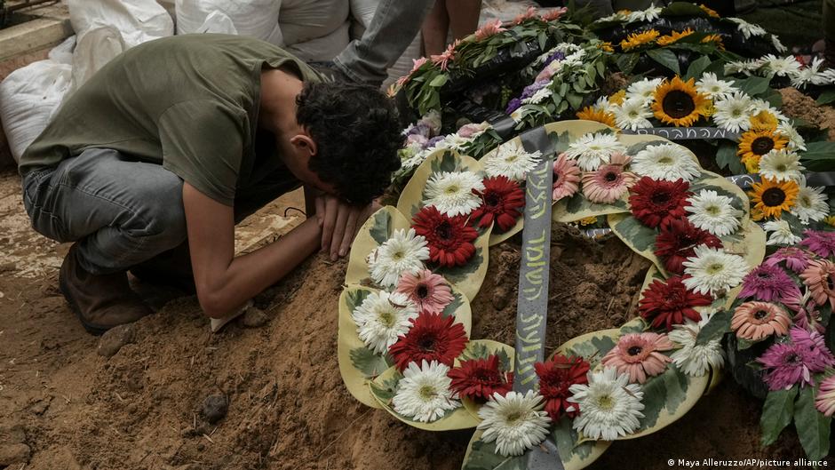 A mourner kneels at a grave of an Israeli victim of a Hamas attack