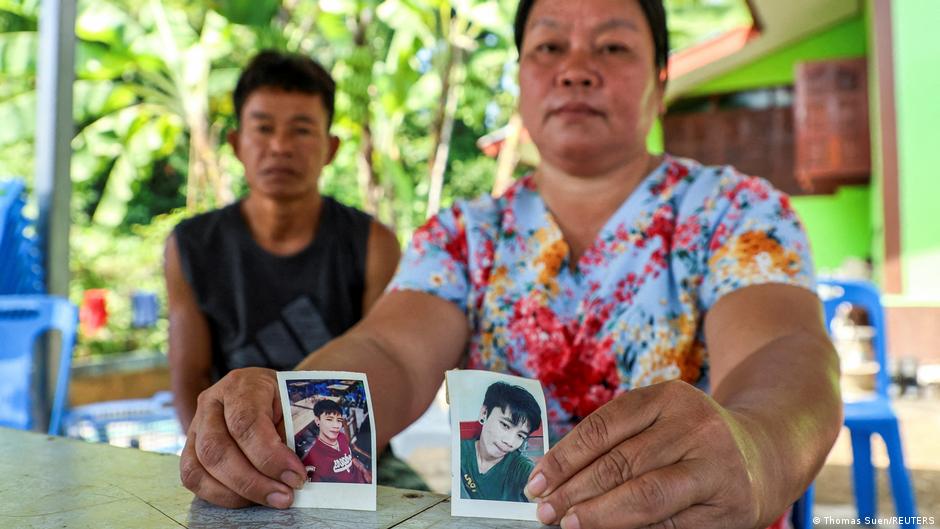 A Thai woman holds photos of her 26-year-old son, who is missing after the Hamas attacks in Israel
