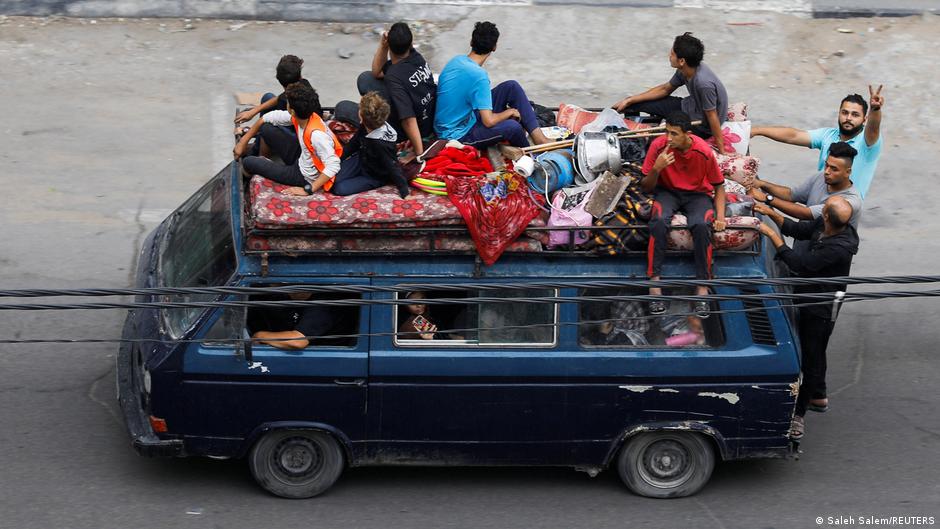 Several people in Gaza are seen sitting on a bus with all their belongings