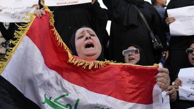 Iraqi women protesting, front one holding Iraqi flag (photo: Picture Alliance/AP | H. Mizban)