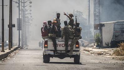 A Toyota truck carrying a group of armed and masked fighters.