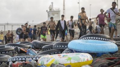 Swimming gear lies scattered on the beach, while people in wet clothes can be seen in the background after emerging from the water.. (Photo: picture alliance / Anadolu | Marcos Moreno)