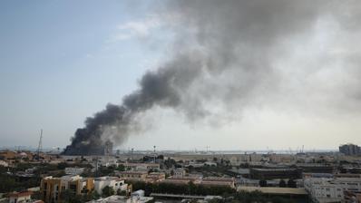 Smoke rises over a city.
