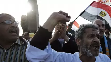 Egyptians waving an Egyptian flag demonstrate against the Muslim Brother Mohammed Morsi