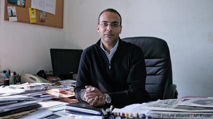Director of the human rights organisation Egyptian Initiative for Personal Rights, Hossam Bahgat sits behind a desk covered in papers