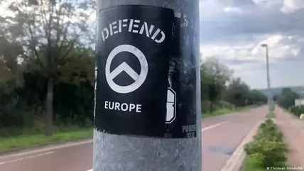 A sticker that says "Defend Europe" attached to a roadside post