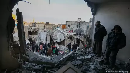 People in Gaza inspect the damage to their homes in Gaza following an Israeli airstrike