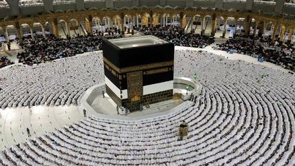 Menschen beten in der Großen Moschee und verneigen sich in Richtung Kaaba 