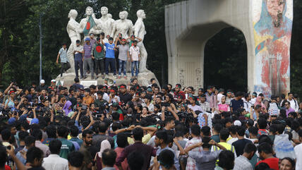 Students demonstrate in Dhaka, Bangladesh, around a monument