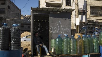 Ein Mann verkauft nach dem Sturz des Assad-Regimes Treibstoff am Straßenrand in Douma, Syrien, am 6. Februar 2025. (Foto: Picture Alliance / Middle East Images | R. Waked) Ein Mann verkauft auf der Straße in Syrien Treibstoff aus Plastikflaschen.