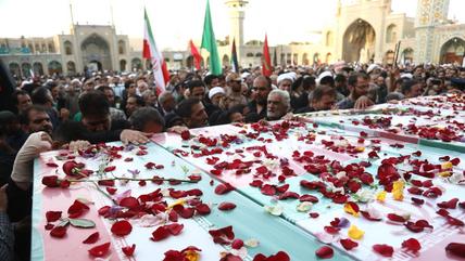Qom, Iran, 16 June 2025. (Photo: Picture Alliance / Anadolu | Stringer) Funeral procession with coffins draped in Iranian flags, strewn with rose petals.