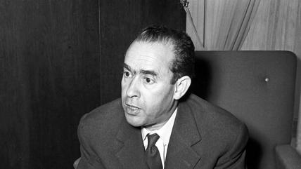 بن بركة جالسًا ويرتدي بدلة رسمية