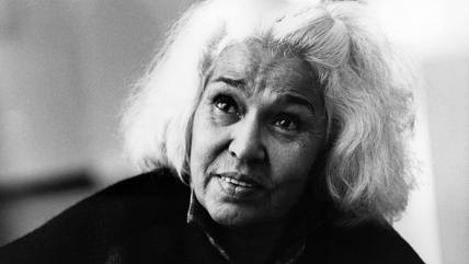 Black and white portrait photo of a woman with white hair.