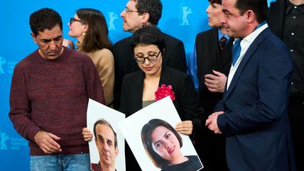 Director Shahrbanoo Sadat, centre with flower, poses with the cast and crew for photographers at the photo call for the film 'No Good Men' during the International Film Festival, Berlinale, in Berlin, Thursday, Feb. 12, 2026.