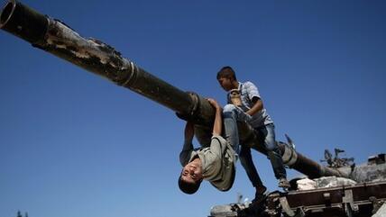 Children playing on a destroyed Syrian tank in Aleppo (photo: AP/Muhammed Muheisen)
