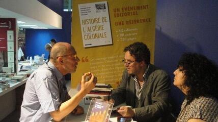 The Algerian writer Amin Zaoui (right) discussing with an attendee of the Algiers Book Fair (photo: Marina Sabra)