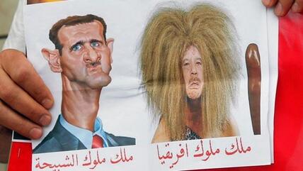 Karikatur von Assad (l.) und Gaddafi (r.) auf einer Solidaritätsdemonstration für die Gegner des syrischen Regimes in Paris; Foto: ddp images/AP Photo/ Francois Mori