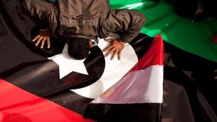 An Egyptian demonstrator on Tahrir Square in Cairo kisses the new Libyan flag out of solidarity with the rebels in Egypt (photo: AP)