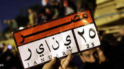 Demonstrant hält Schild mit Hinweis auf den Beginn der ägyptischen Revolution vom 25. Januar; Foto: dpa