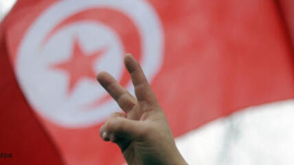 Tunisian flag and victory sign (photo: dpa)