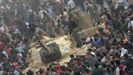 A crowd surrounding an Egyptian military tank at Tahrir Square in Cairo (photo: dpa)