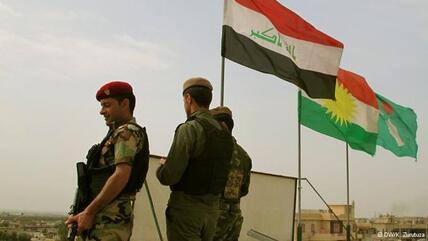 Soldiers seen standing in front of the Iraqi (left) and Kurdish (centre) flags (photo: DW/K. Zurutuza)